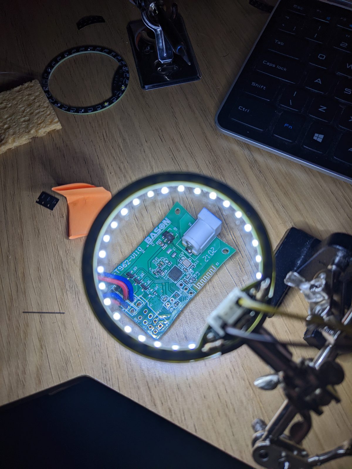 The lit LED ring fitted in the magnifying glass, with a green circuit board visible through the lens